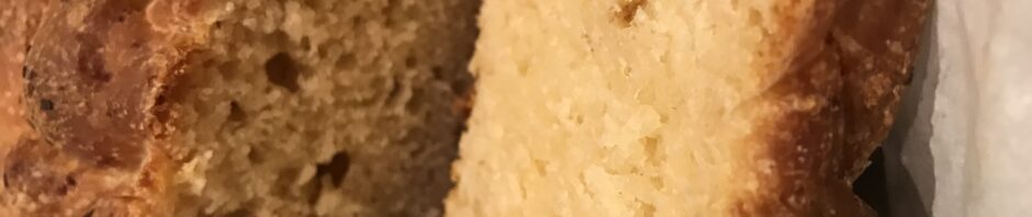 A loaf of home made bread with a slice next to it